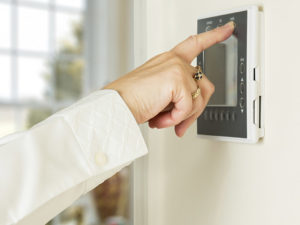 Person Adjusting Thermostat