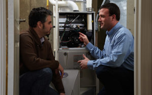 Technician Talking To Man About Furnace