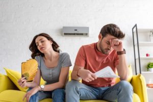 Couple Fanning Themselves On Couch