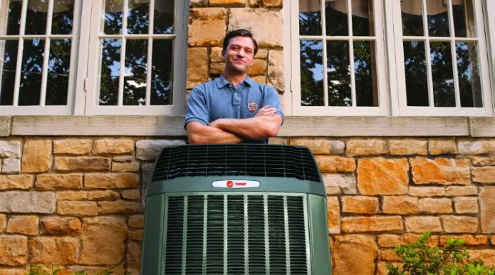 Trane Dealer Standing Behind Air Conditioner